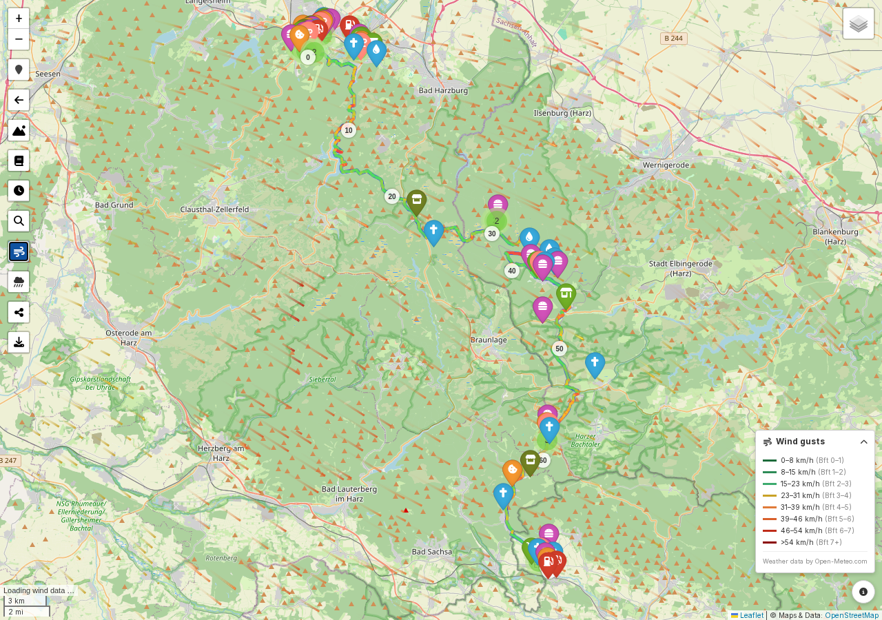 Screenshot: a route map with the wind overlay active, showing both the wind-particle field and the route colored by headwind/tailwind
